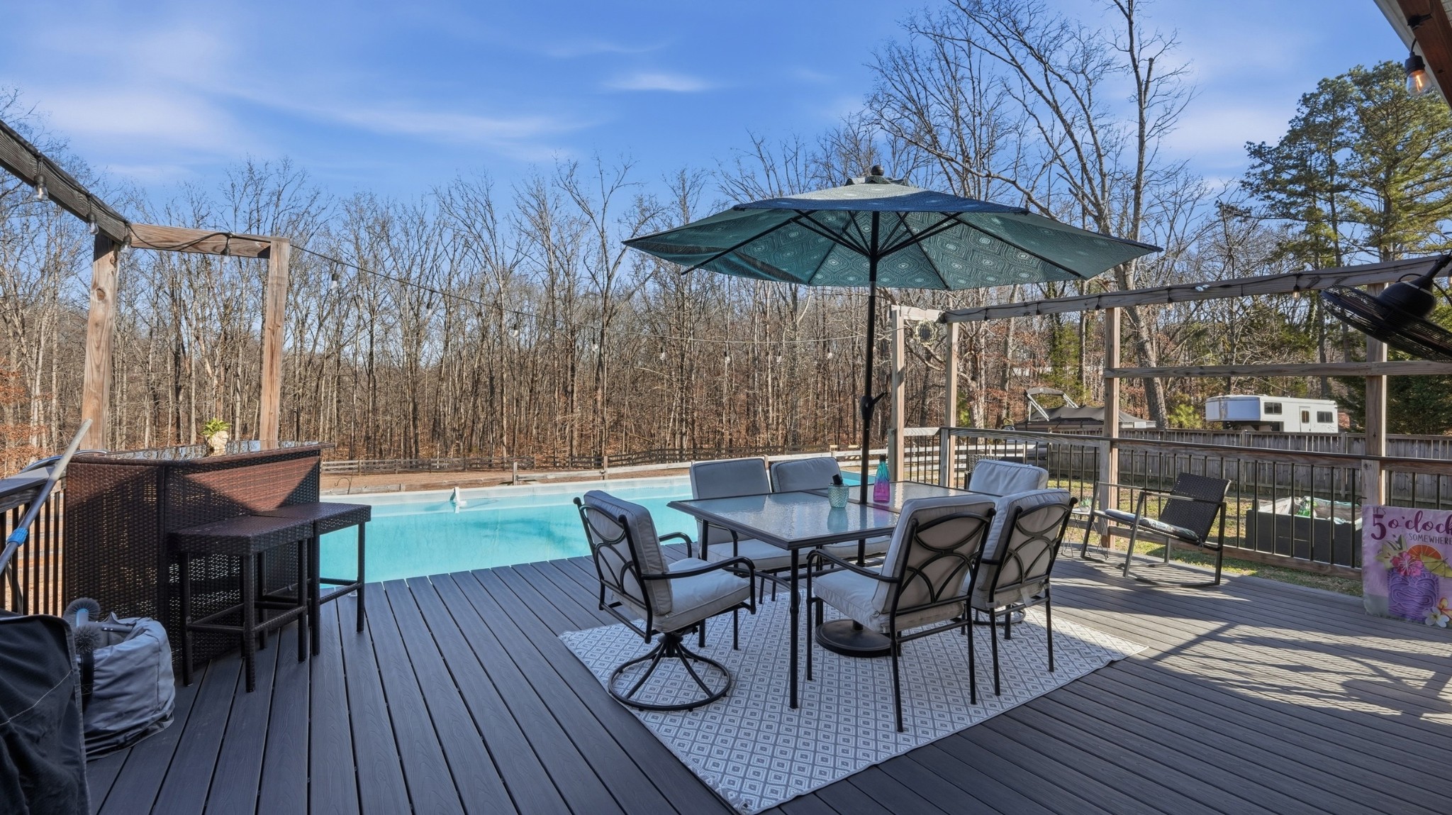 135 Vols Lane Estill Springs, TN 37330 - Photo 34 of 56 a view of a roof deck with table and chairs under an umbrella with wooden floor