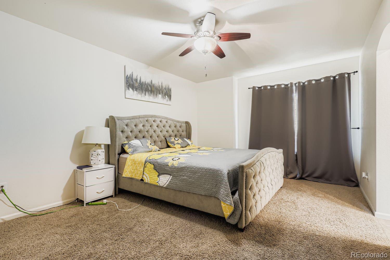 5545 Liverpool Street Denver, CO 80249 - Photo 15 of 28 a bedroom with a bed and a chandelier