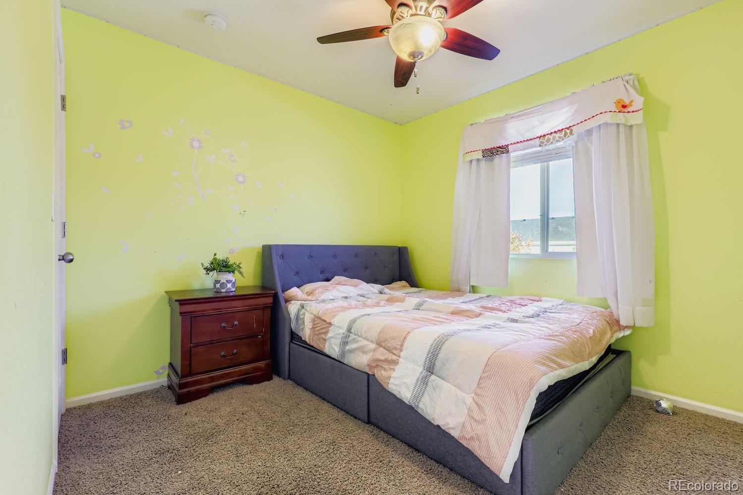 5545 Liverpool Street Denver, CO 80249 - Photo 18 of 28 a bedroom with a bed and a chandelier