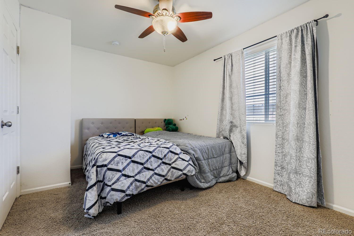 5545 Liverpool Street Denver, CO 80249 - Photo 21 of 28 a bedroom with a bed and window