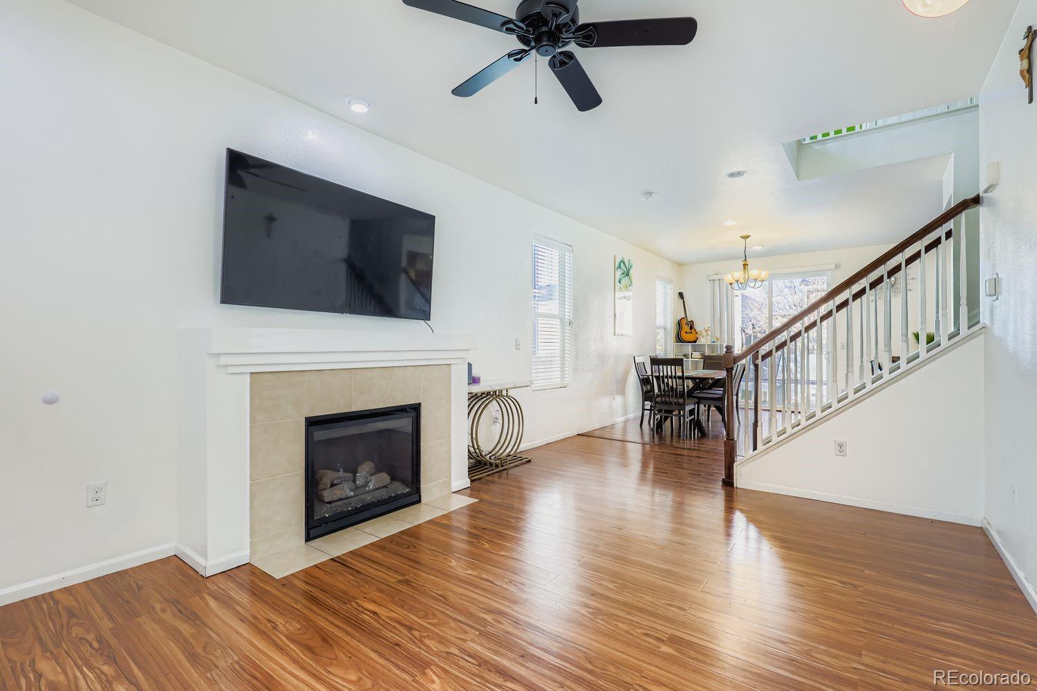 5545 Liverpool Street Denver, CO 80249 - Photo 5 of 28 a living room with furniture a fireplace and a flat screen tv