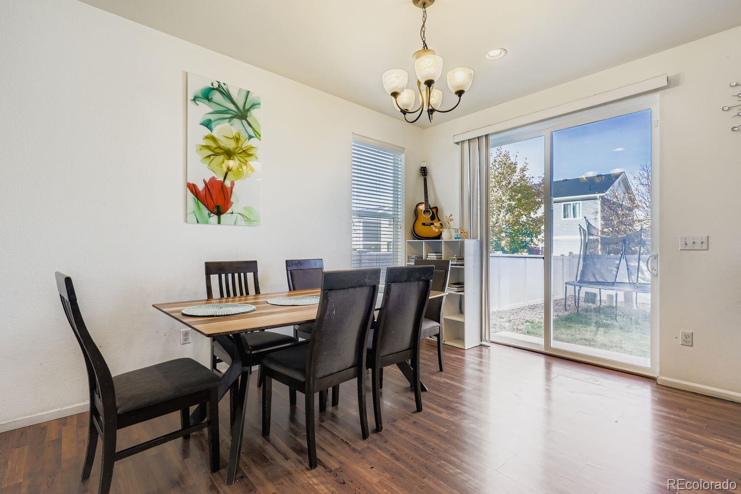 5545 Liverpool Street Denver, CO 80249 - Photo 8 of 28 a view of a dining room with furniture a chandelier and wooden floor