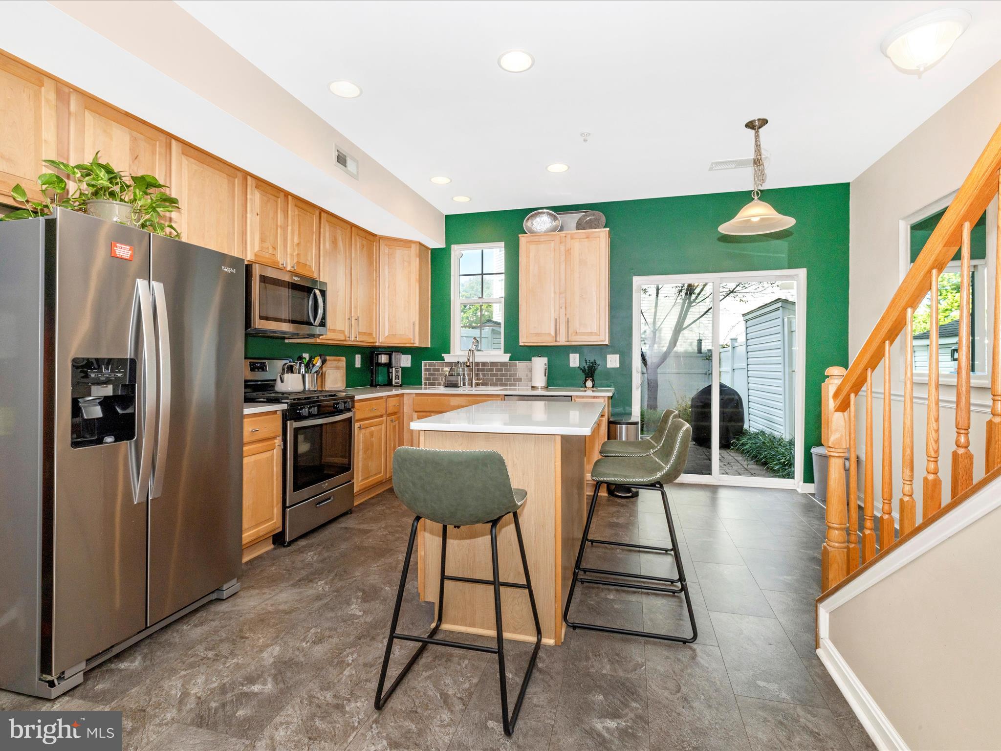 648 Tivoli Road Frederick, MD 21703 - Photo 13 of 51 a kitchen with stainless steel appliances kitchen island granite countertop a refrigerator a stove a oven a sink with island chairs and wooden floor