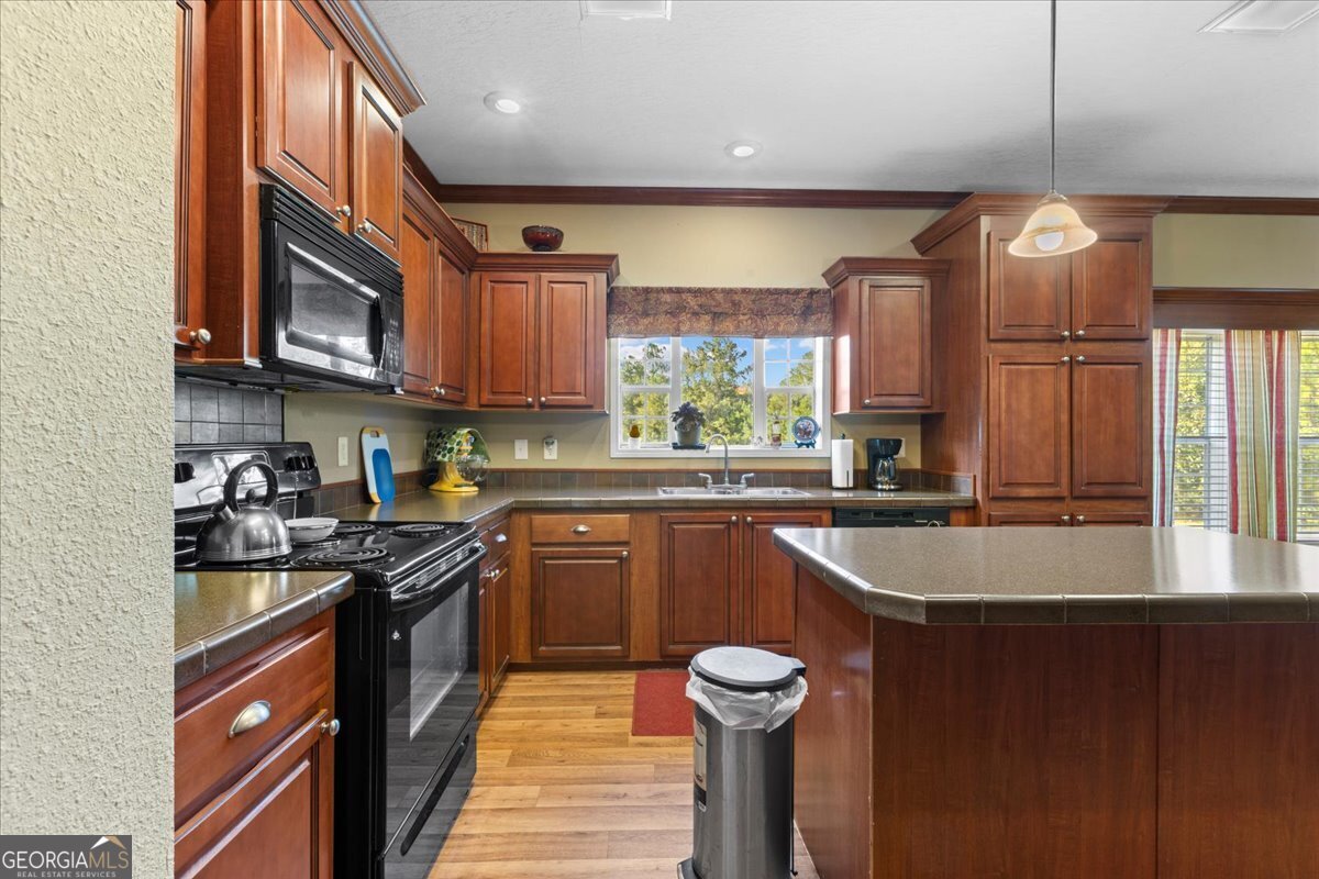 2273 Ga Highway 110 Folkston, GA 31537 - Photo 24 of 42 a kitchen with stainless steel appliances granite countertop a sink a stove and a wooden cabinets