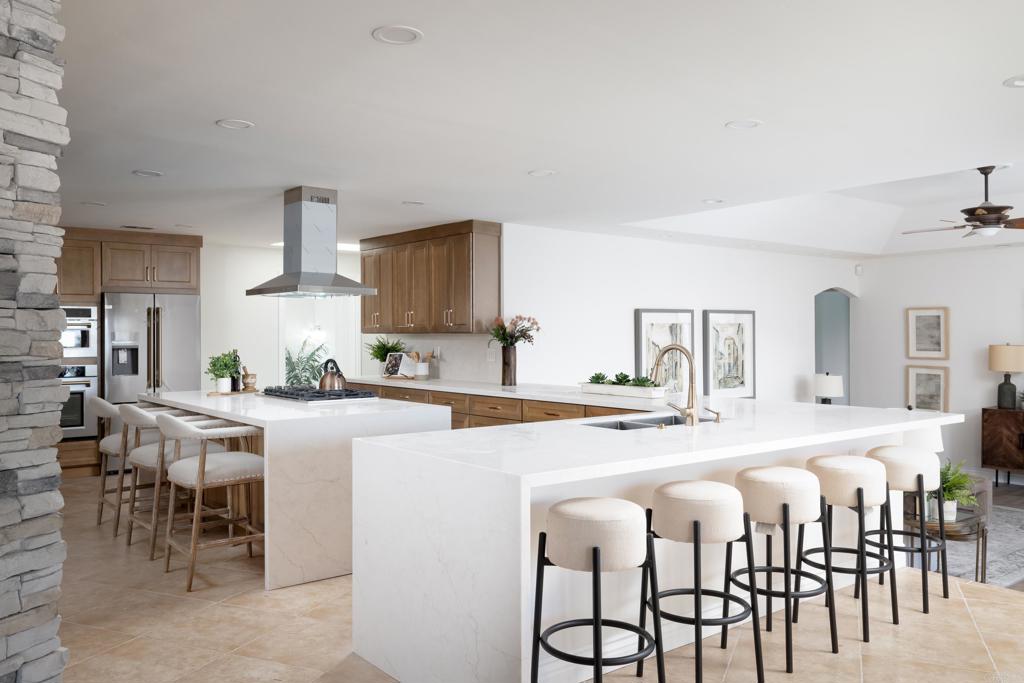 15017 Skyridge Road Poway, CA 92064 - Photo 8 of 54 a kitchen with stainless steel appliances kitchen island granite countertop a table chairs sink and cabinets