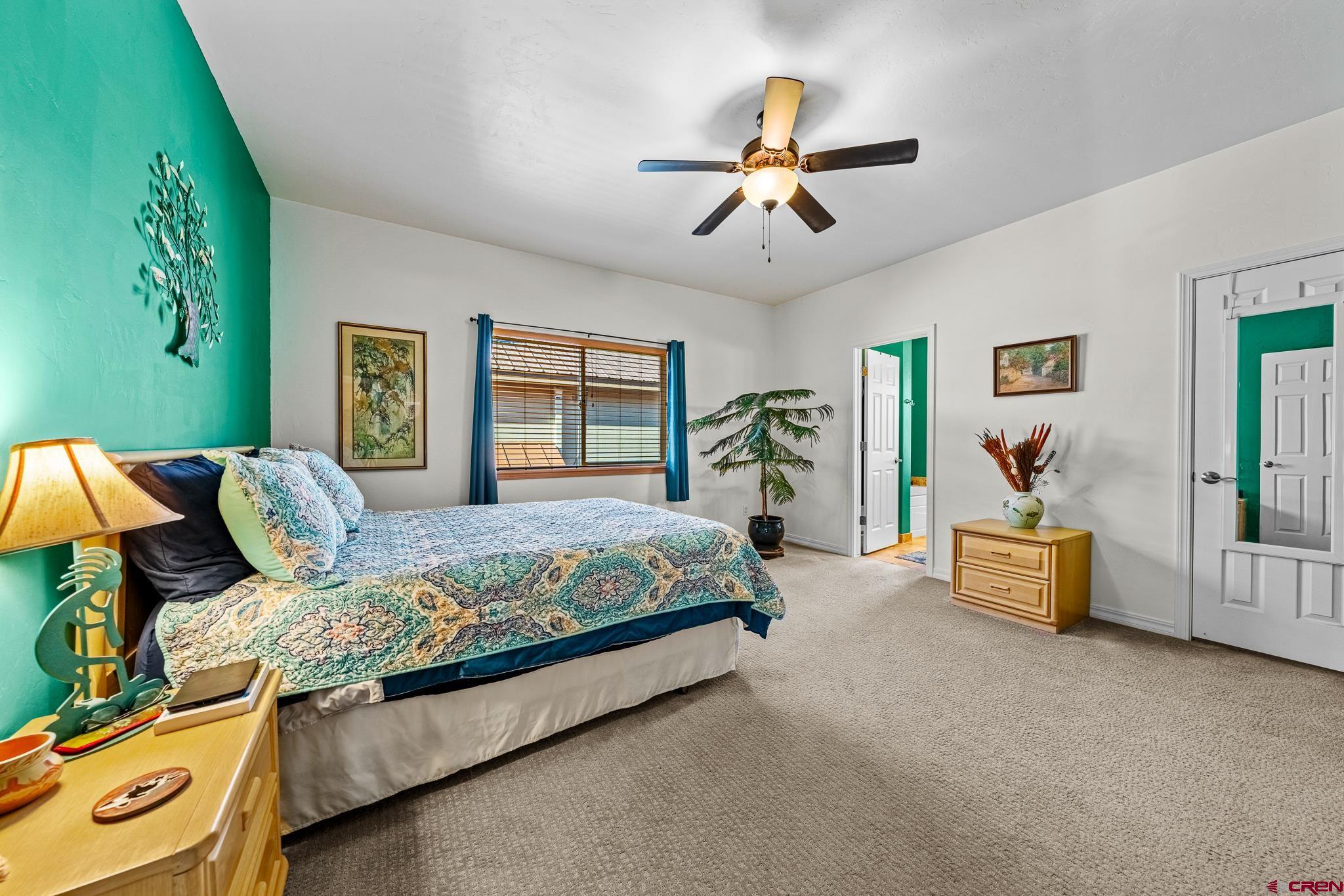 72 Cedar Ridge Way Durango, CO 81301 - Photo 13 of 33 a bedroom with a large bed and a chandelier