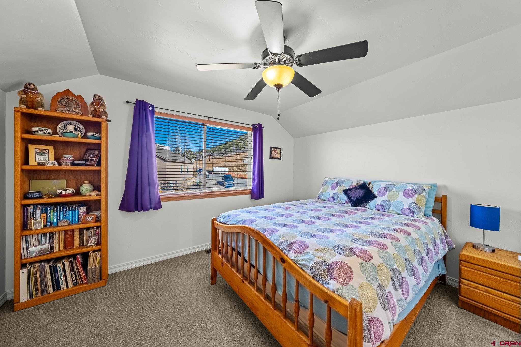 72 Cedar Ridge Way Durango, CO 81301 - Photo 18 of 33 a bedroom with a bed a book shelf and a chandelier