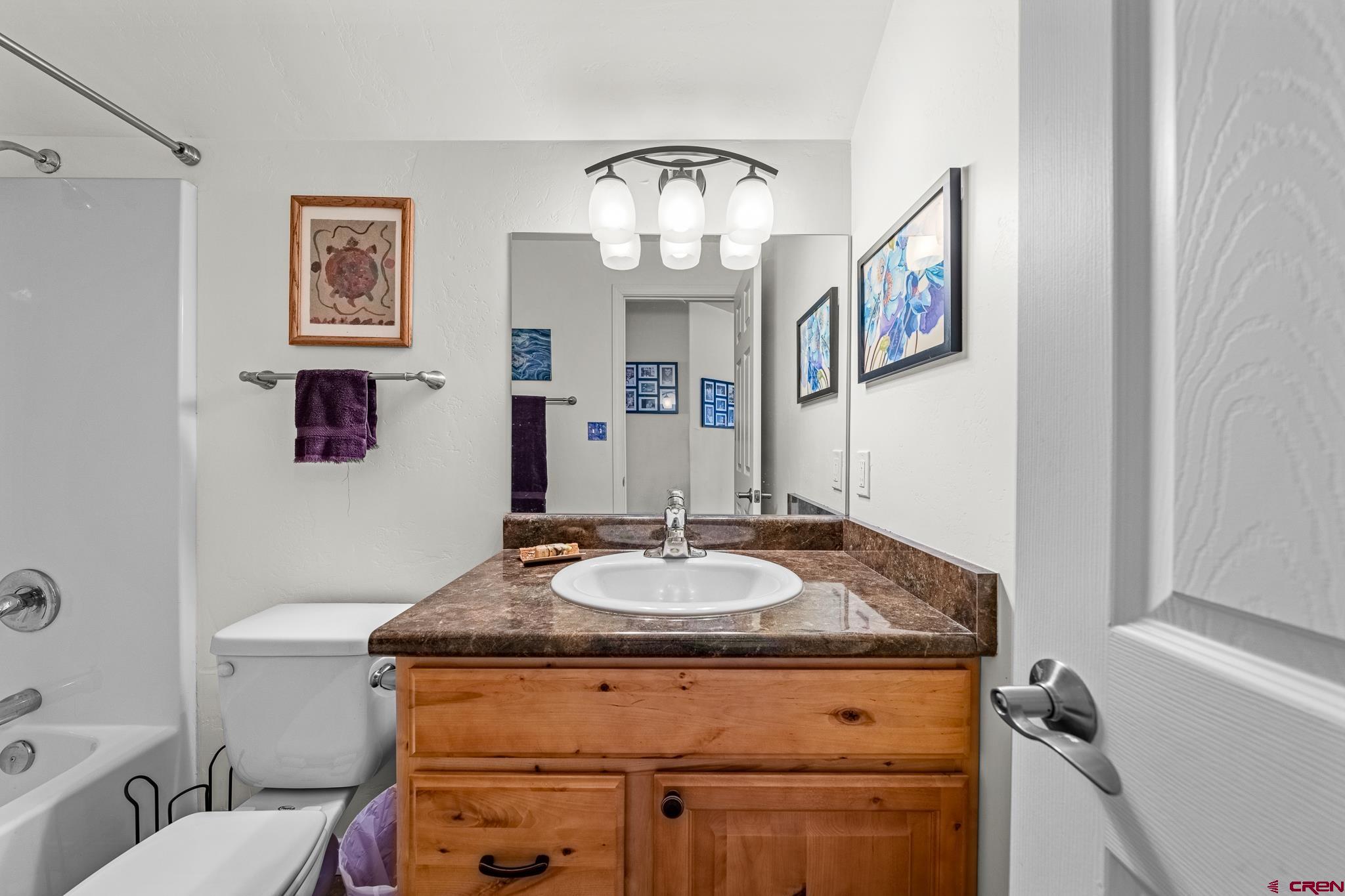 72 Cedar Ridge Way Durango, CO 81301 - Photo 21 of 33 a bathroom with a granite countertop sink a mirror and a toilet