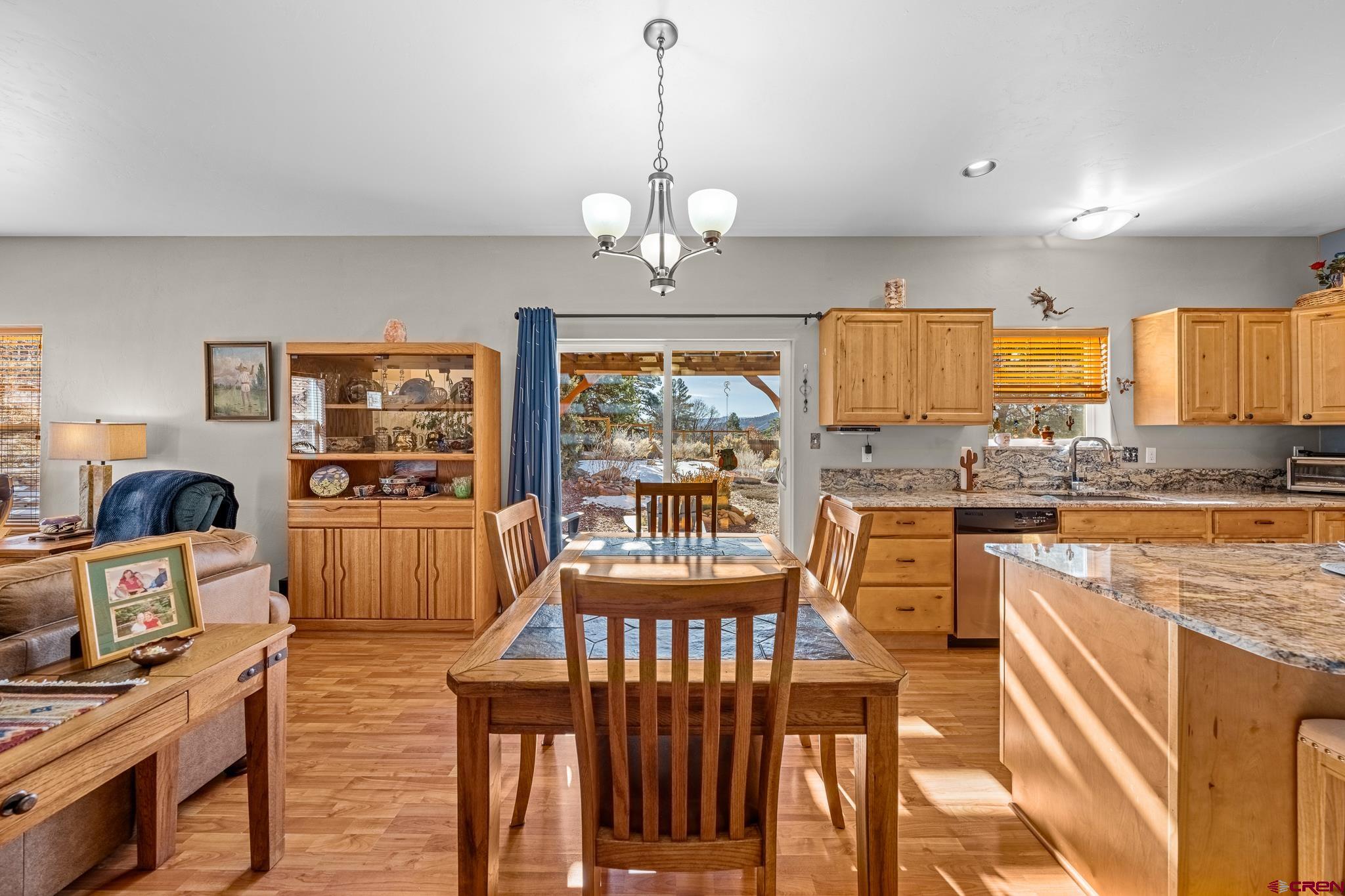 72 Cedar Ridge Way Durango, CO 81301 - Photo 6 of 33 a view of a kitchen with granite countertop a stove top oven a sink dishwasher a dining table and chairs with wooden floor