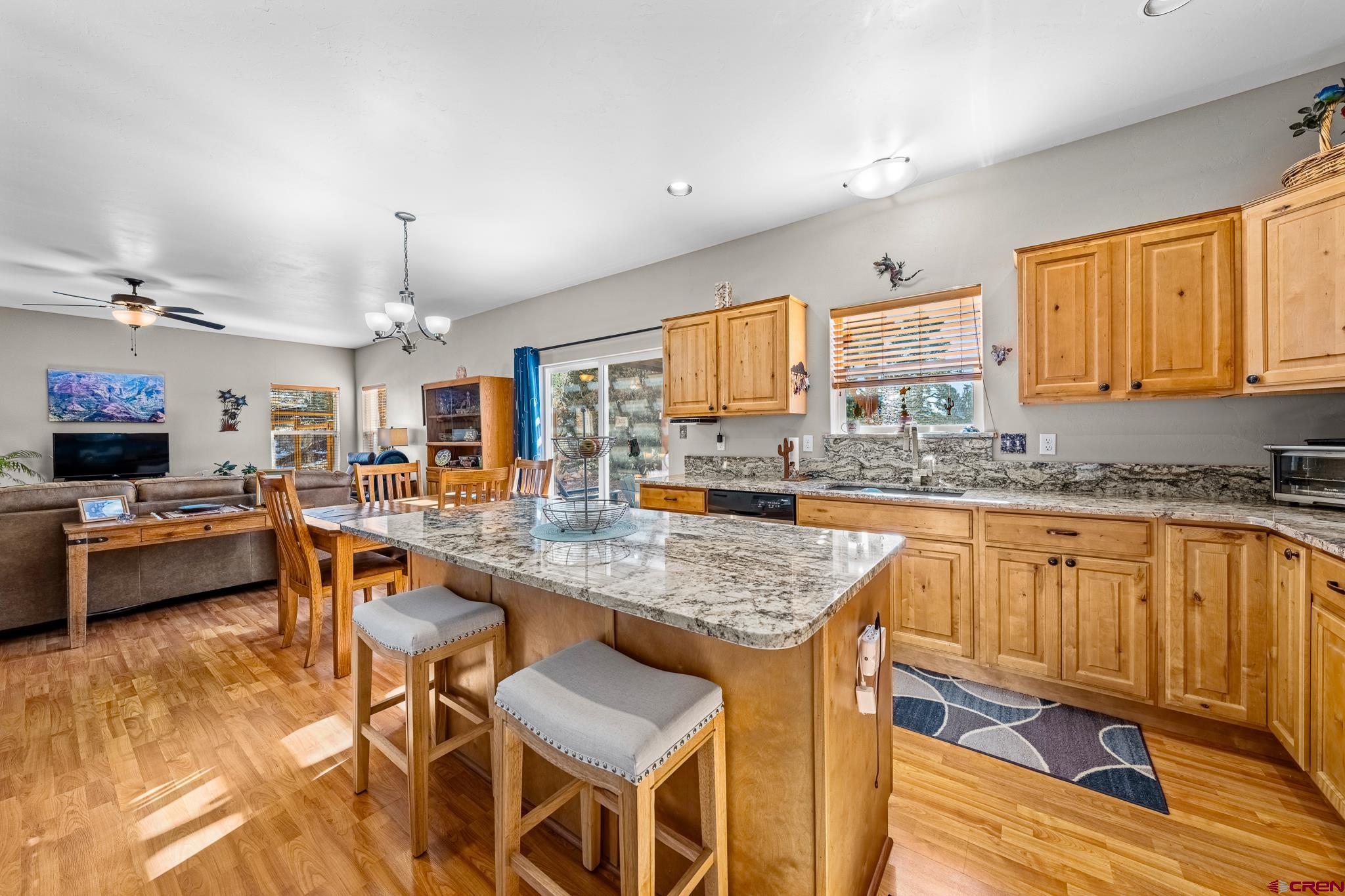72 Cedar Ridge Way Durango, CO 81301 - Photo 7 of 33 a kitchen with stainless steel appliances granite countertop wooden cabinets a dining table and chairs