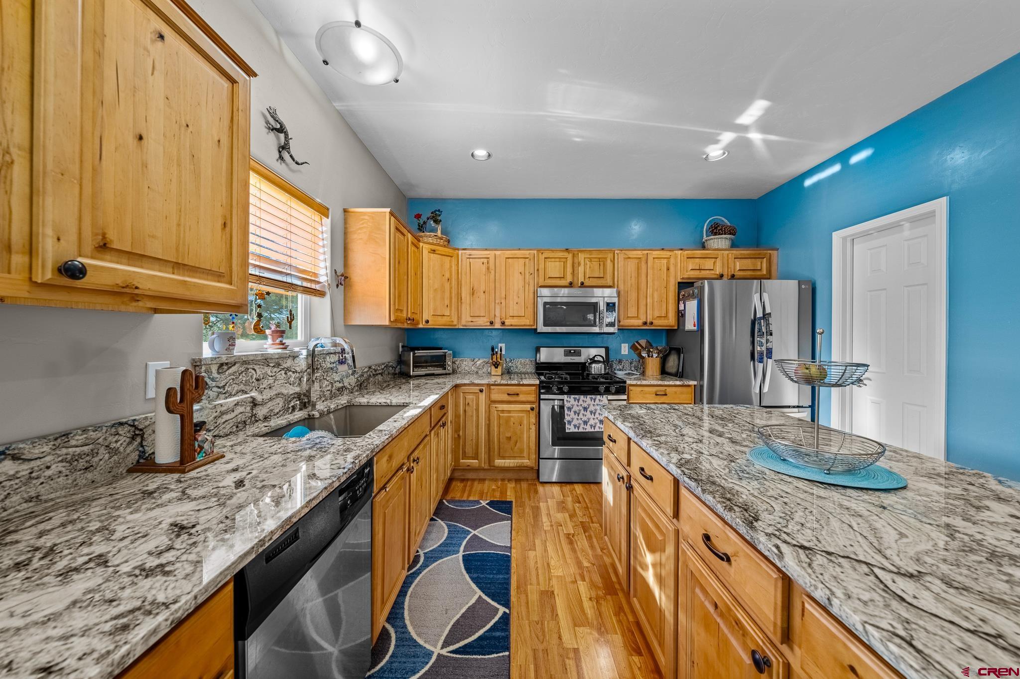 72 Cedar Ridge Way Durango, CO 81301 - Photo 10 of 33 a kitchen with stainless steel appliances granite countertop a sink a stove and a wooden floors
