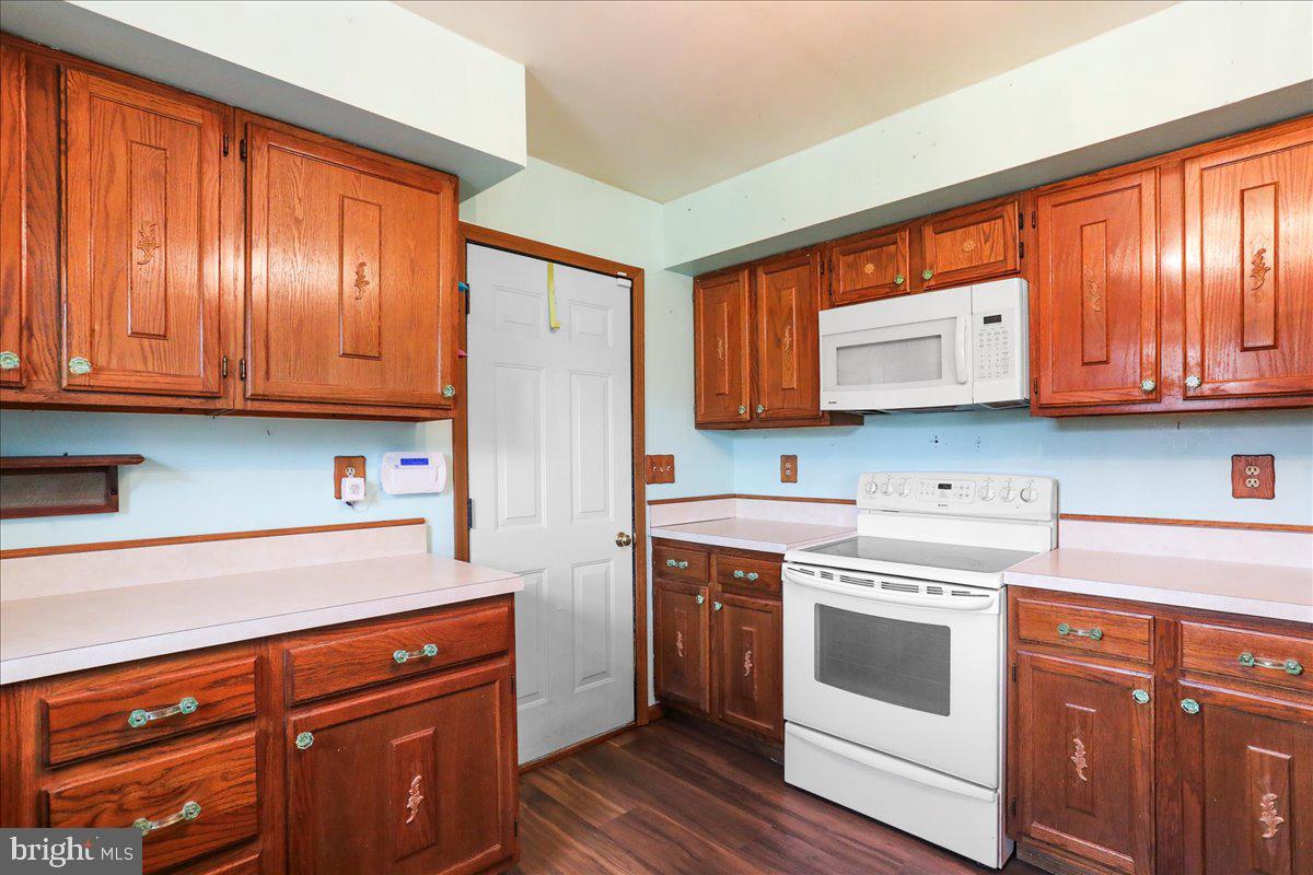 4045 North Stone Road Taneytown, MD 21787 - Photo 12 of 45 a kitchen with stainless steel appliances granite countertop a stove a sink dishwasher and a refrigerator with wooden cabinets