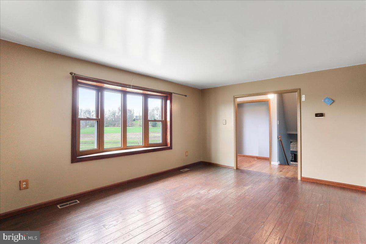 4045 North Stone Road Taneytown, MD 21787 - Photo 7 of 45 an empty room with wooden floor and windows