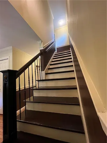 a hallway with wooden floor chandelier table and chairs