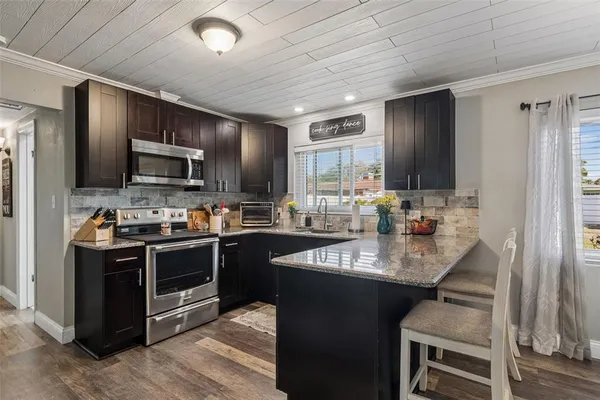 a kitchen with kitchen island granite countertop a sink stove and refrigerator