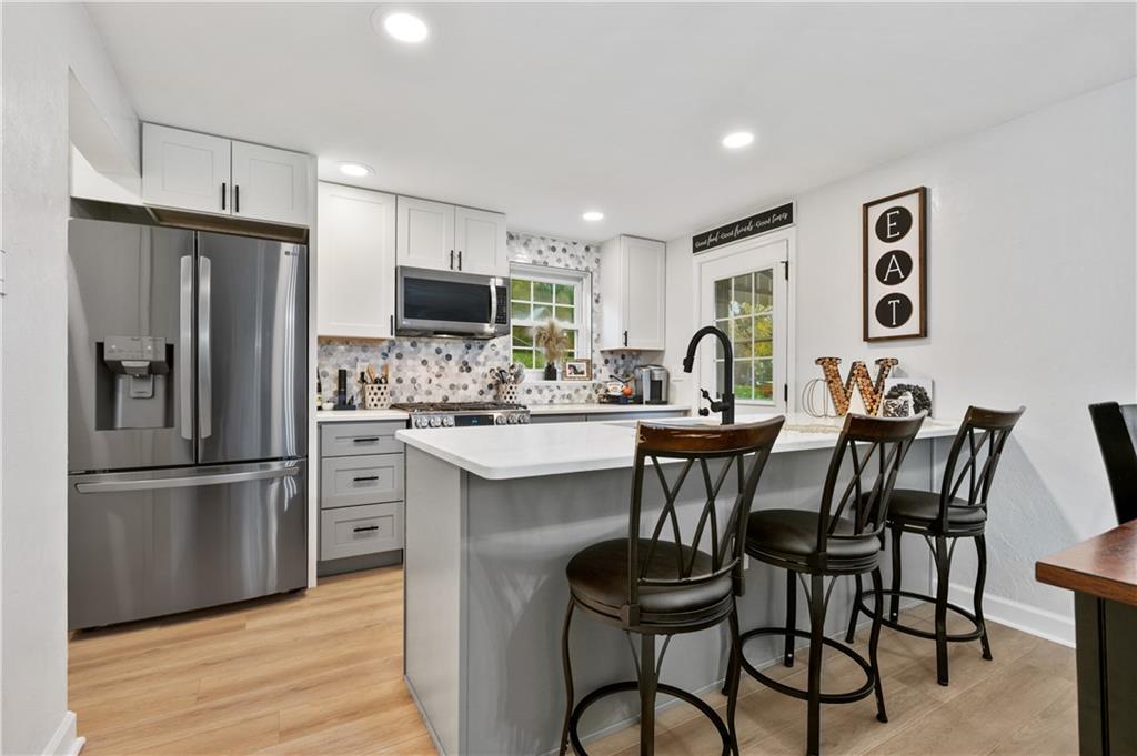 5300 Spring Valley Drive Pittsburgh, PA 15236 - Photo 8 of 25 a kitchen with stainless steel appliances kitchen island granite countertop a refrigerator and a stove top oven