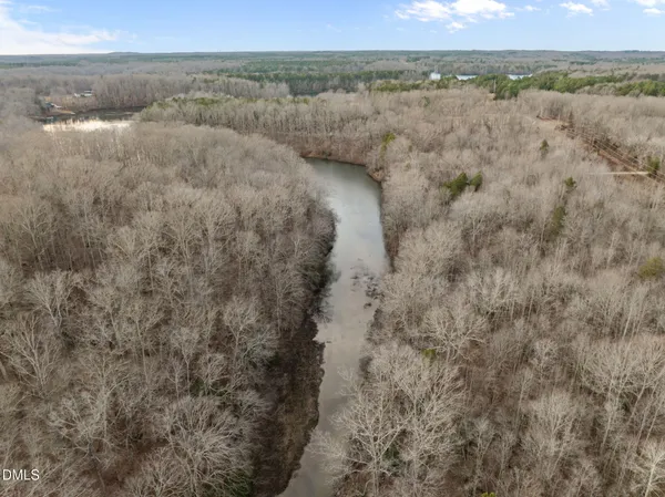 a view of a lake in middle of a field