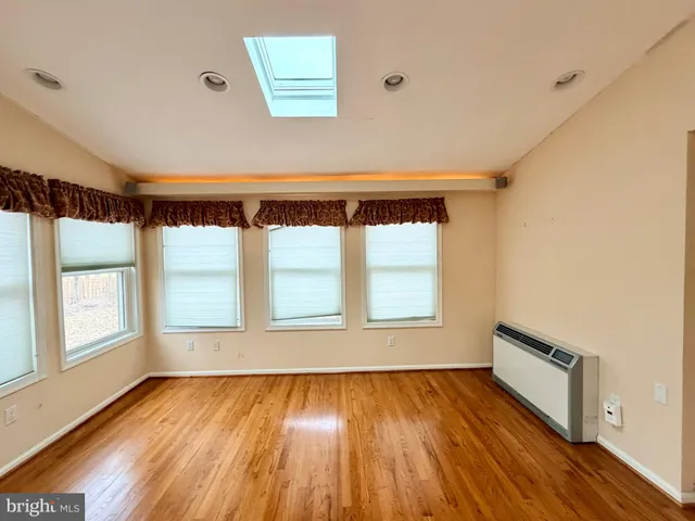 a view of a hallway with wooden floor and a chandelier