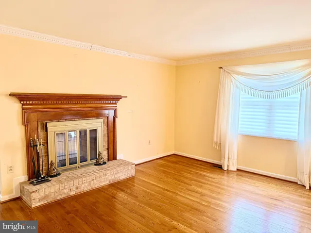 a view of a livingroom with wooden floor and a ceiling fan