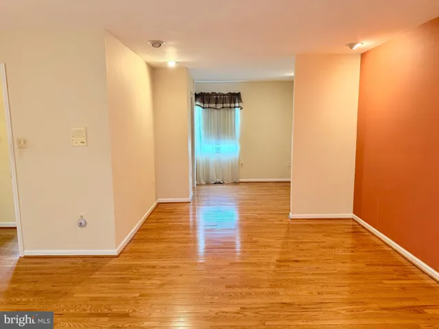 a view of a livingroom with wooden floor and furniture