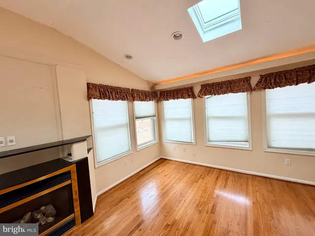 a kitchen with stainless steel appliances granite countertop a refrigerator a stove and a sink with wooden floor