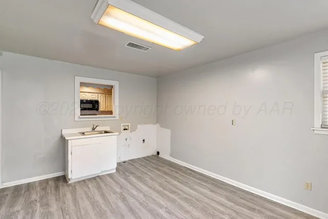 an empty room with a window and a ceiling fan