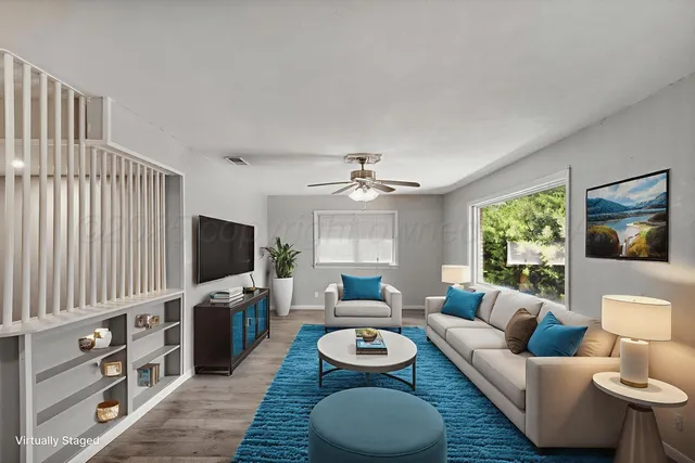 a living room with furniture a window and a flat screen tv