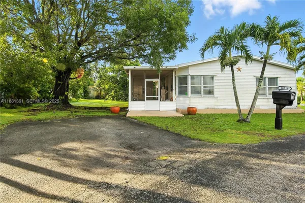 a view of a house with backyard and a tree