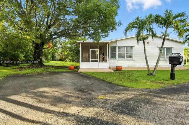 a view of a house with backyard and a tree