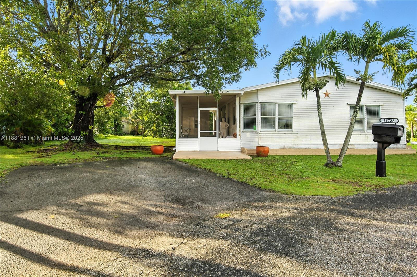 a view of a house with backyard and a tree
