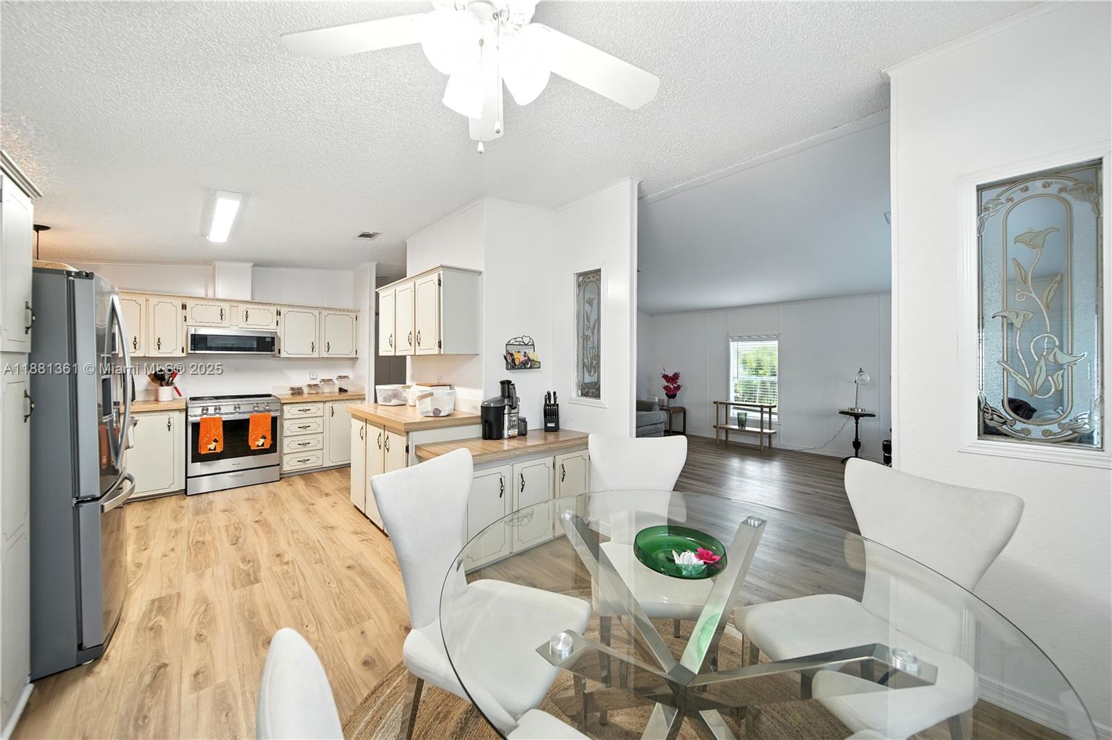 18728 Southwest 349th Street, Unit 442 Homestead, FL 33034 - Photo 7 of 15 a living room with stainless steel appliances kitchen island granite countertop furniture a rug kitchen view and a chandelier
