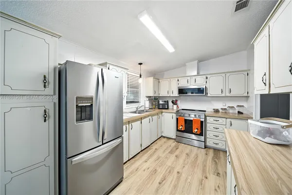a kitchen with stainless steel appliances a refrigerator sink and microwave