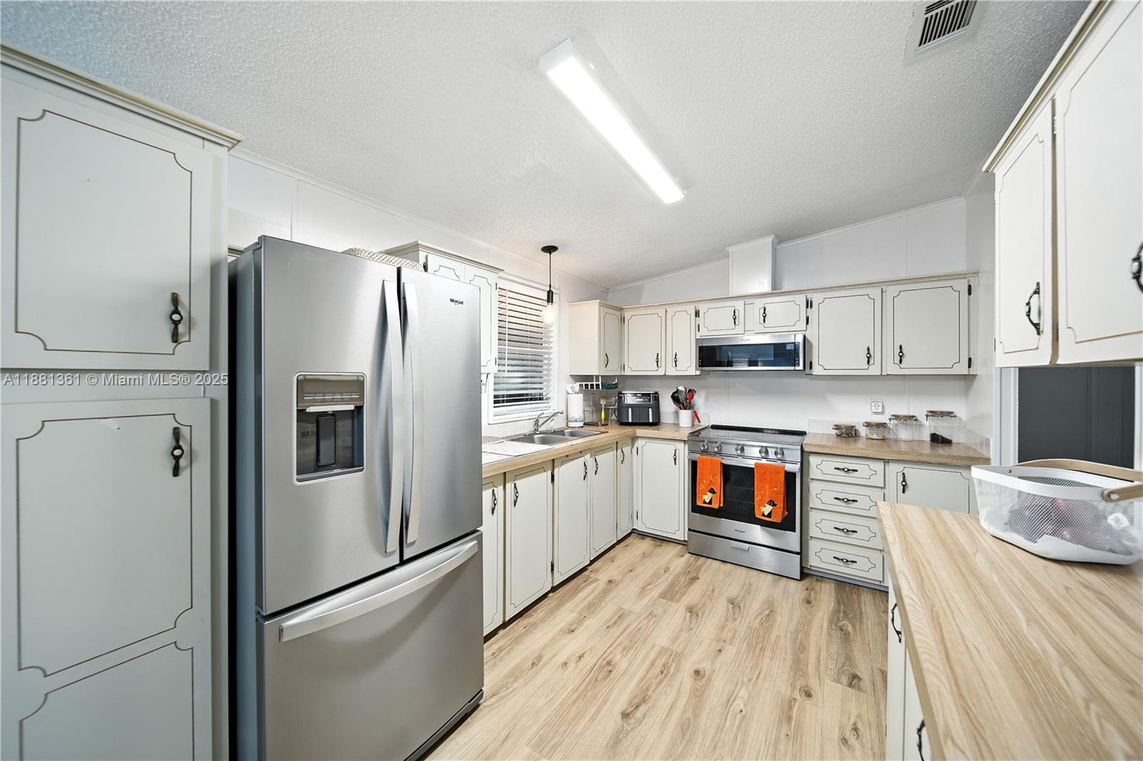 18728 Southwest 349th Street, Unit 442 Homestead, FL 33034 - Photo 8 of 15 a kitchen with stainless steel appliances a refrigerator sink and microwave
