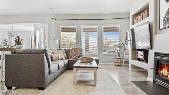 a living room with furniture couches and a dining table with wooden floor