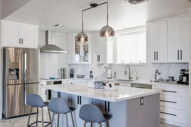 a kitchen with stainless steel appliances a sink stove refrigerator and cabinets