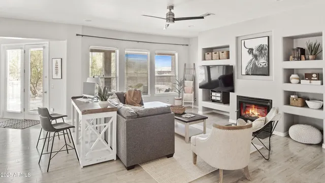 a living room with furniture a flat screen tv and a table