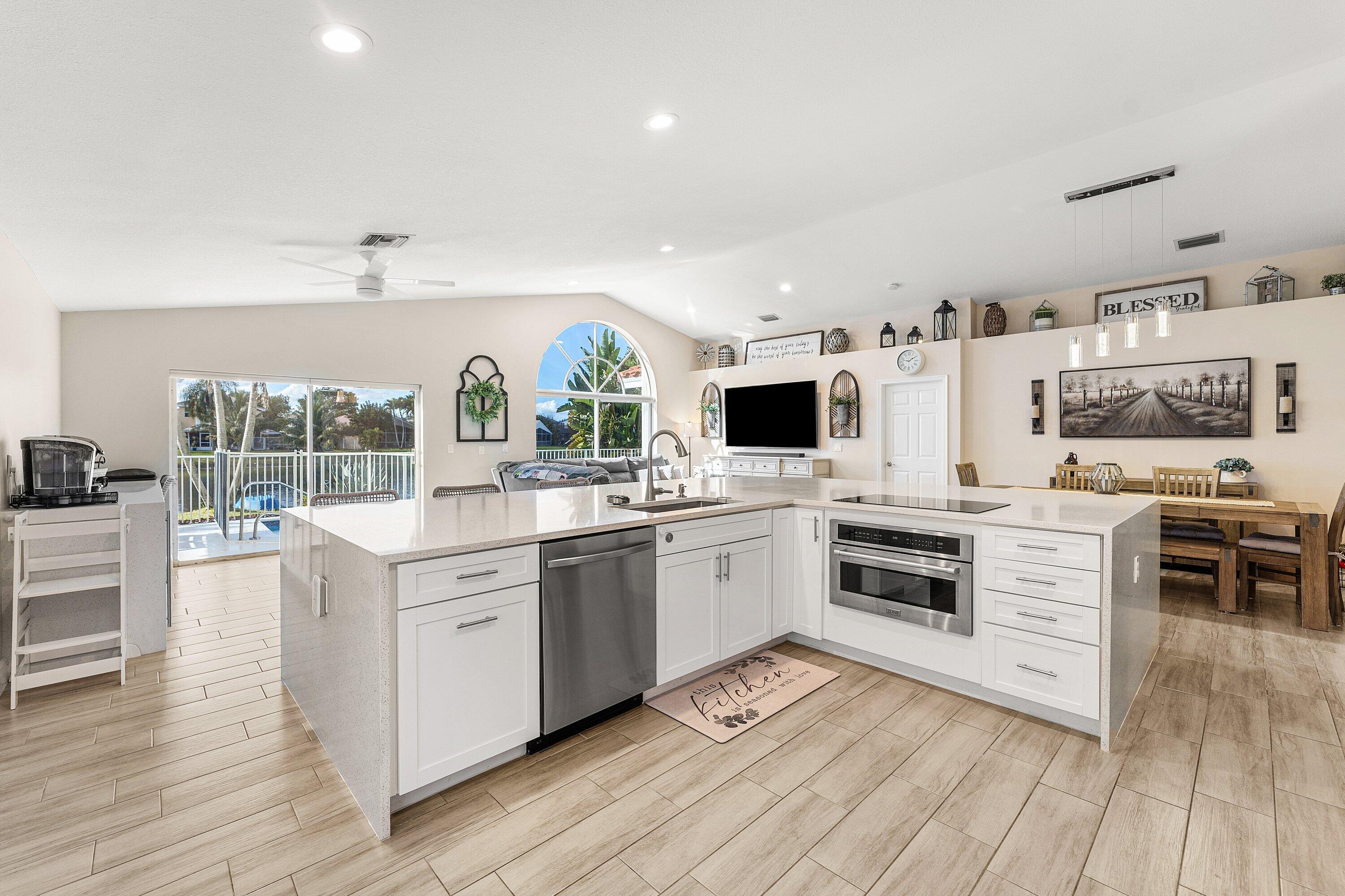 7346 Michigan Isle Road Lake Worth, FL 33467 - Photo 12 of 44 a kitchen with stainless steel appliances granite countertop a stove and a sink