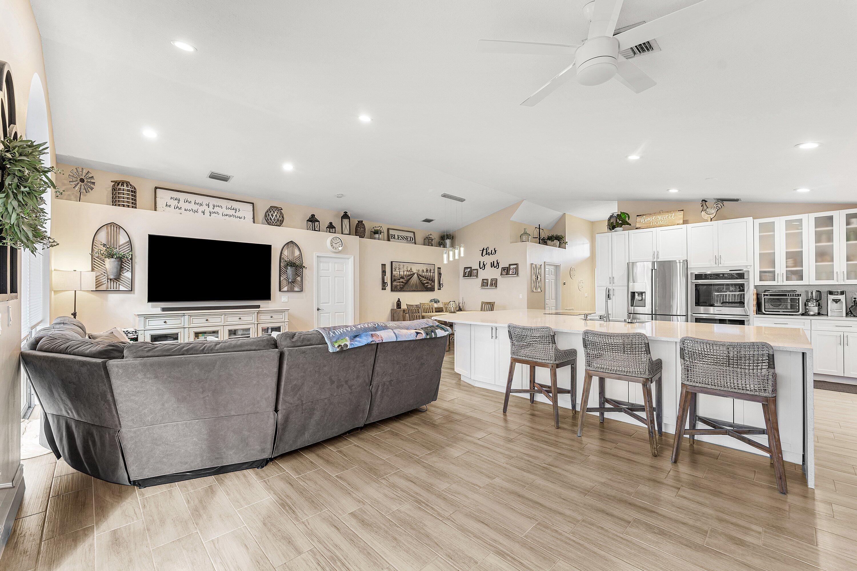 7346 Michigan Isle Road Lake Worth, FL 33467 - Photo 13 of 44 a living room with furniture and a flat screen tv