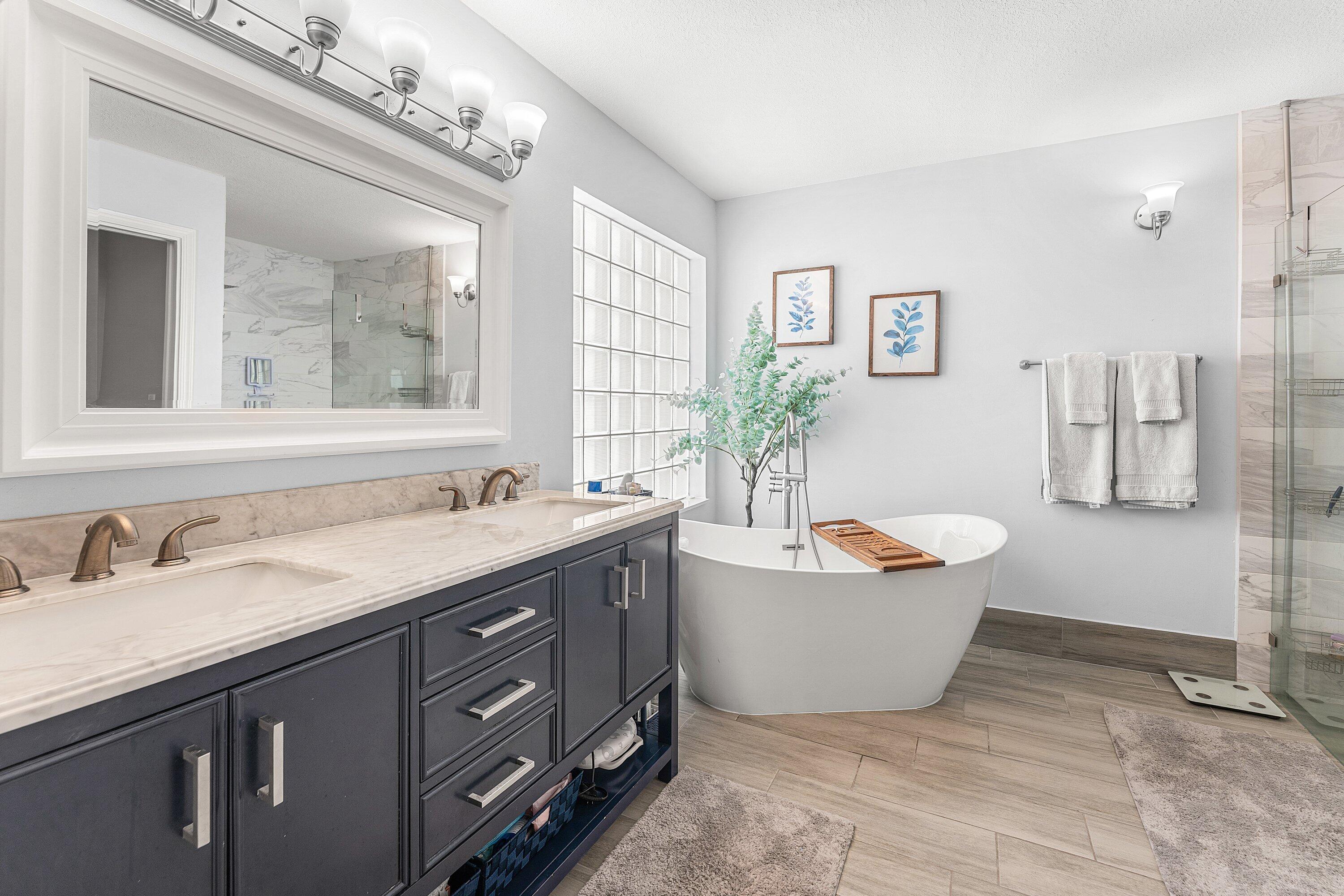 7346 Michigan Isle Road Lake Worth, FL 33467 - Photo 19 of 44 a spacious bathroom with a granite countertop tub sink and mirror