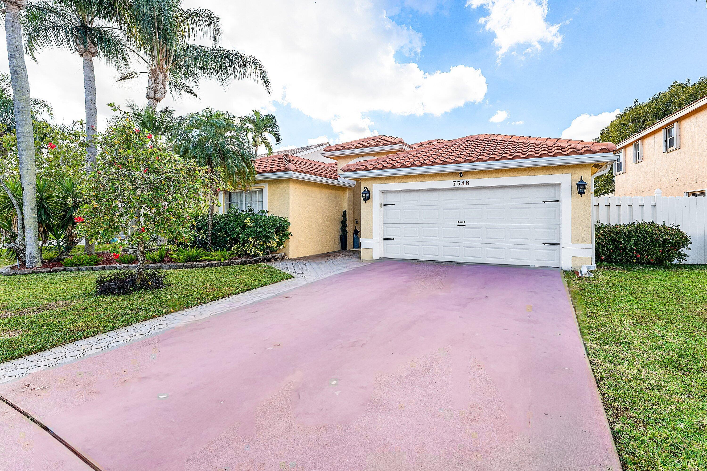 7346 Michigan Isle Road Lake Worth, FL 33467 - Photo 2 of 44 a view of a house with a yard and palm trees