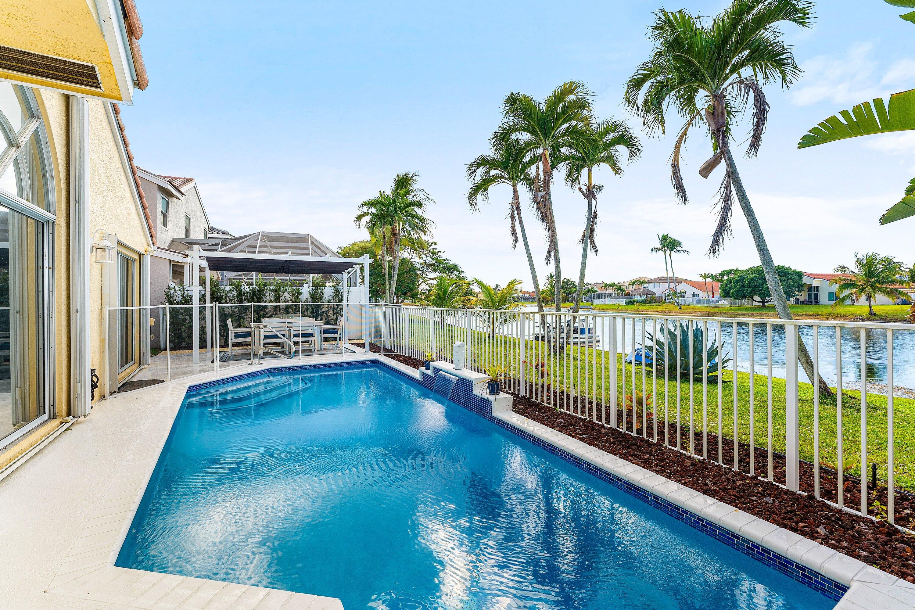 7346 Michigan Isle Road Lake Worth, FL 33467 - Photo 30 of 44 a view of swimming pool with outdoor seating and lake view