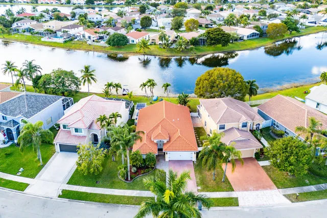 an aerial view of residential houses with outdoor space and lake view