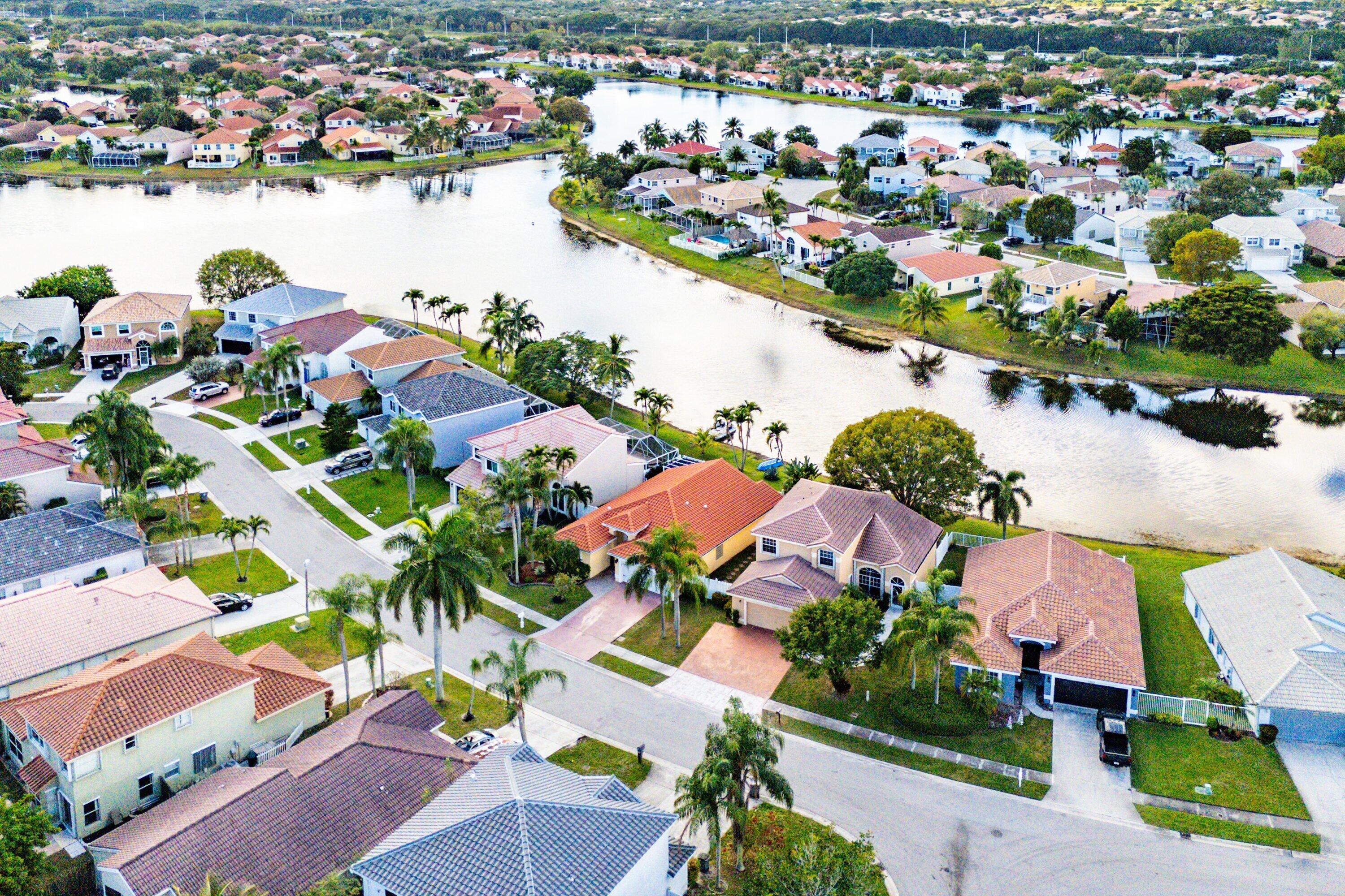 7346 Michigan Isle Road Lake Worth, FL 33467 - Photo 40 of 44 an aerial view of lake and residential houses with outdoor space