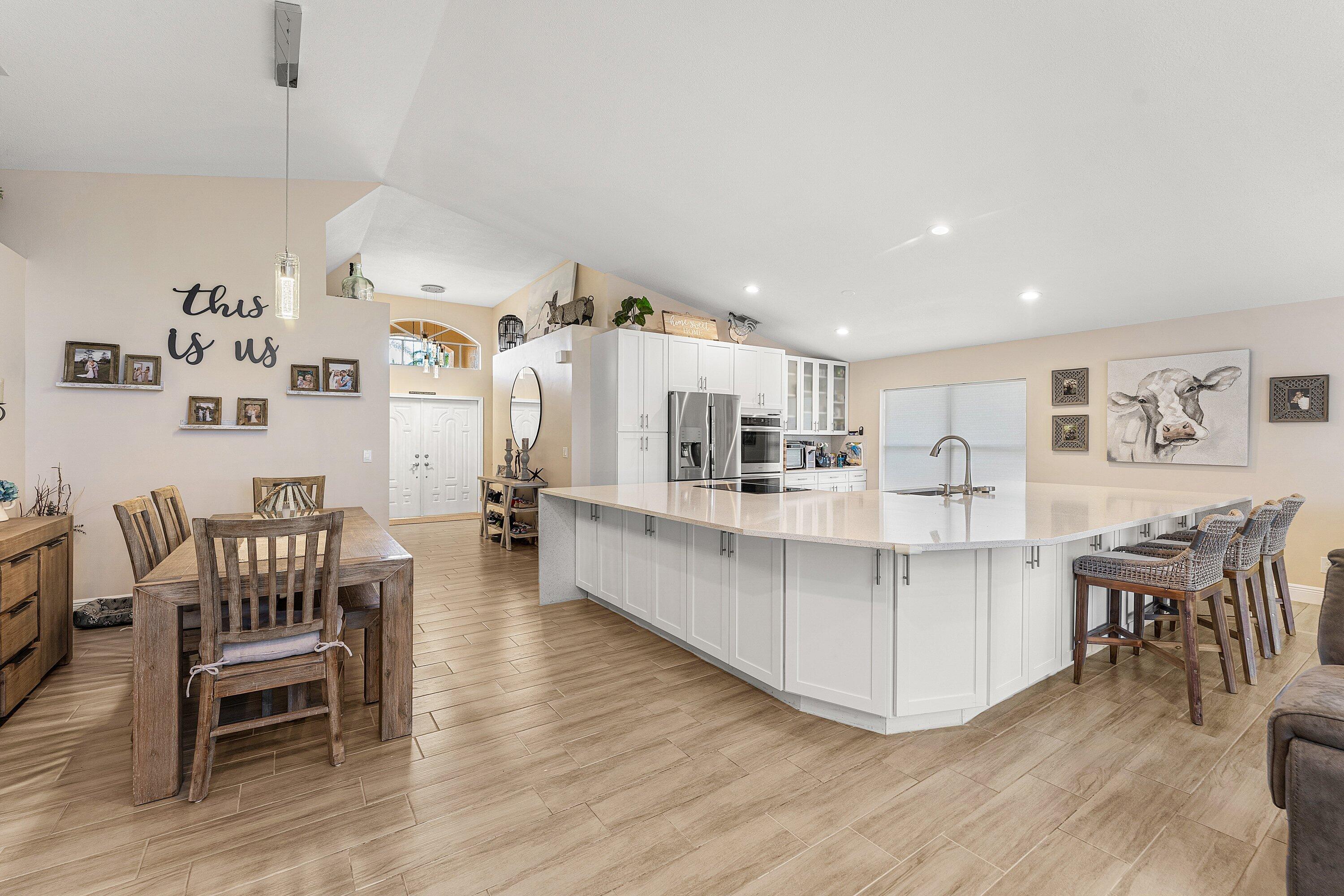 7346 Michigan Isle Road Lake Worth, FL 33467 - Photo 10 of 44 a living room with furniture and a dining table with wooden floor