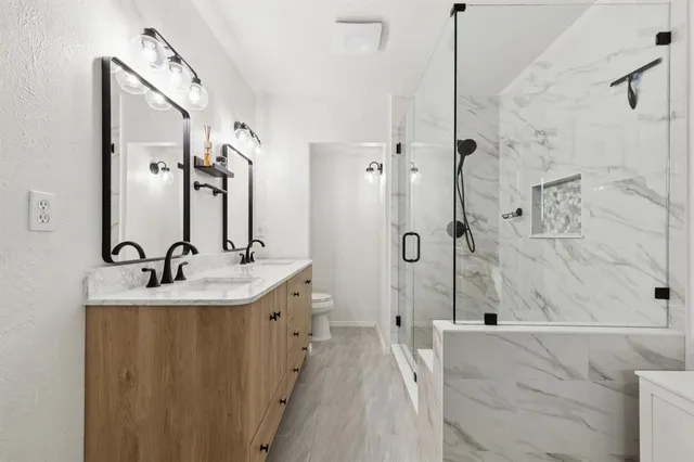 a bathroom with a sink a toilet and shower