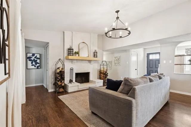 a living room with furniture a fireplace and wooden floor