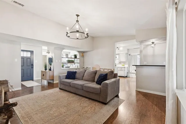 a living room with furniture wooden floor and a chandelier