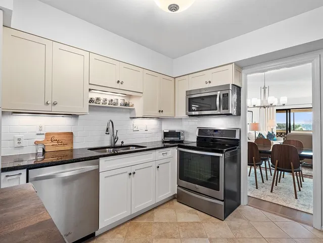 a kitchen with granite countertop a refrigerator stove and microwave