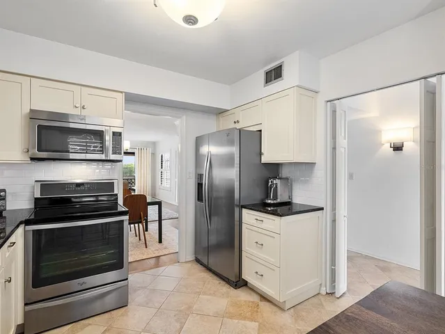 a view of a livingroom and dining room with furniture wooden floor a rug and a chandelier