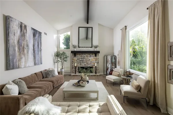 a living room with furniture fireplace and a large window